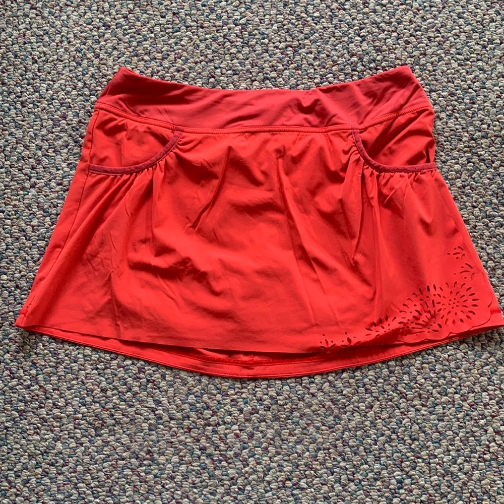 Coral colored Athleta tennis skirt with pockets and built in shorts, size M